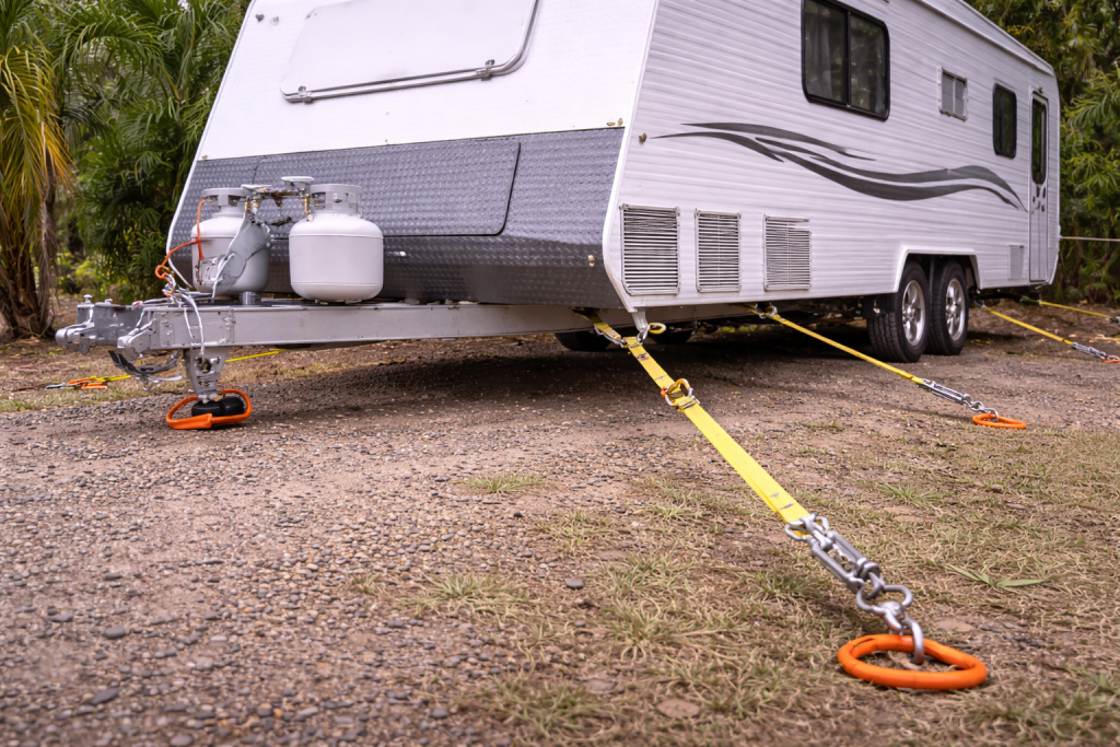 Caravan secured with ground anchors and tie-downs