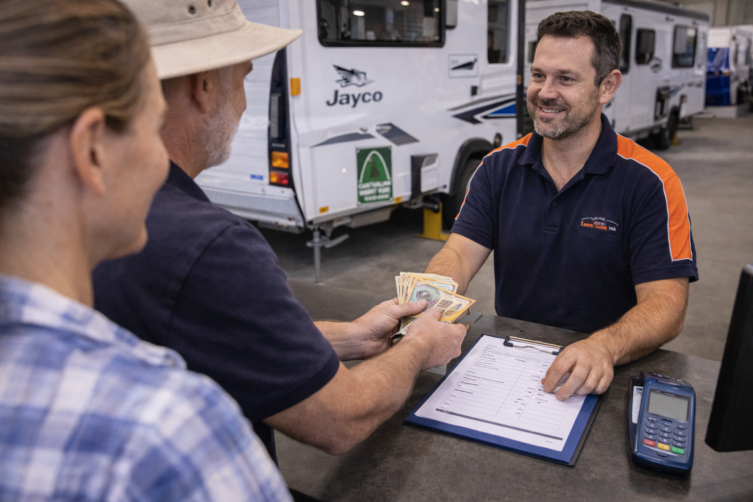 Caravan owner handing over payment at a dealership